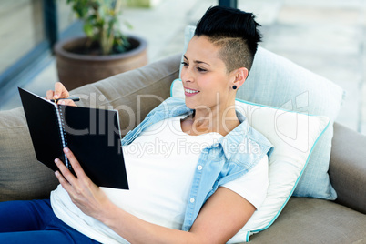 Pregnant woman writing on notepad