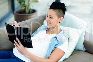 Pregnant woman writing on notepad