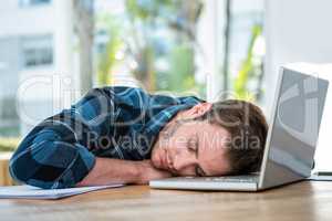 Handsome man sleeping on laptop