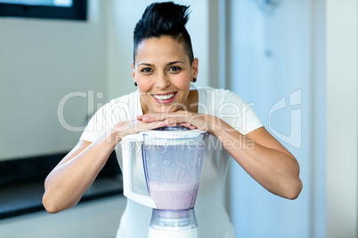 Pregnant woman leaning on blender