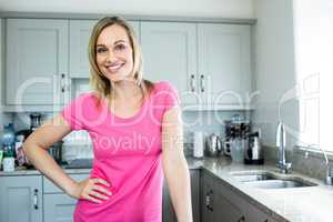 Pretty blonde woman standing in the middle of her kitchen