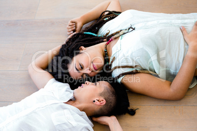 Lesbian couple lying on wooden floor