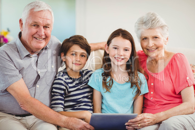 Senior couple using digital tablet with their grand children