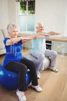 Senior couple exercising on exercise ball