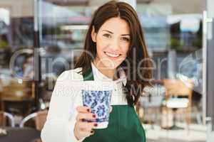 Smiling waitress serving a coffee