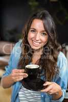 Smiling brunette drinking coffee