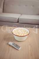 Bowl of popcorn and television remote on table