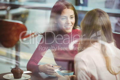 Pretty friends chatting over coffee