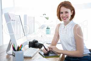 smiling hipster businesswoman writing on a digital drawing table