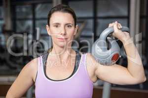 Smiling woman holding heavy kettlebell