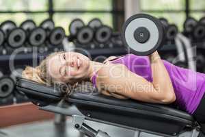 Smiling woman working out with dumbbells