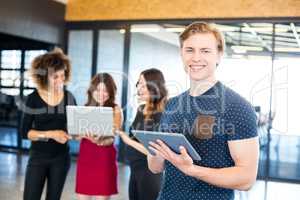 Portrait of man smiling and holding digital tablet