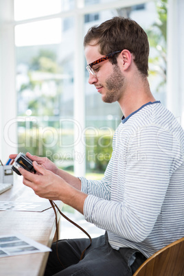 Handsome man looking at pictures on camera