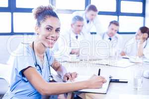 Portrait of female doctors writing on clipboard