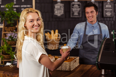 Smiling waiter serving a coffee to a customer