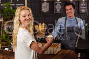 Smiling waiter serving a coffee to a customer