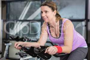 Smiling woman using exercise bike