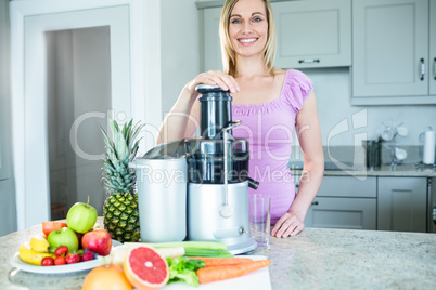 Blonde woman preparing a smoothie in the kitchen