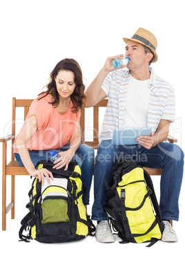 Couple on bench using tablet