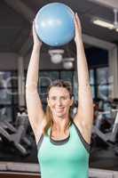 Smiling blonde holding exercise ball