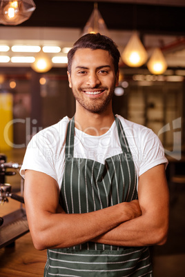 Handsome barista posing with arms crossed