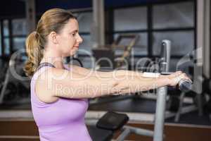 Determined woman lifting dumbbells