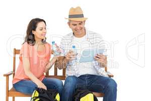 Couple on bench using tablet