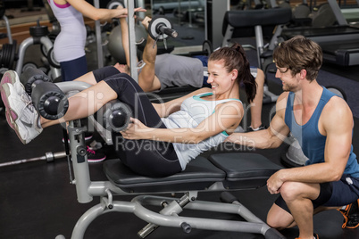 Trainer man helping woman doing her crunches