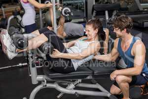 Trainer man helping woman doing her crunches