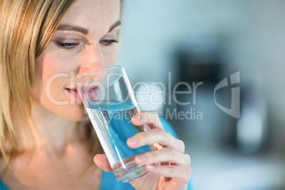 Pretty blonde woman drinking a glass of water