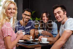 Smiling friends enjoying coffee together