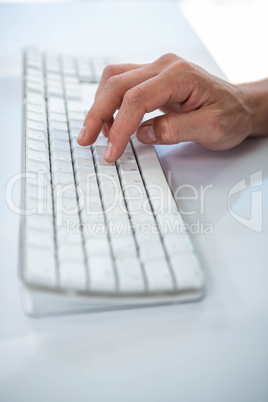 Close up view of a male hand typing on keyboard