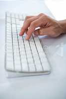 Close up view of a male hand typing on keyboard