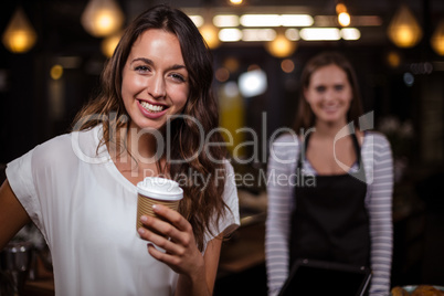 Smiling woman holding disposable cup