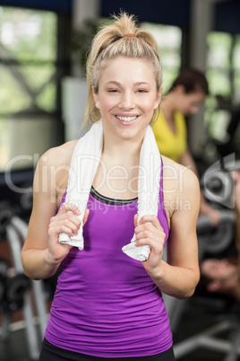 Fit woman smiling and holding towel