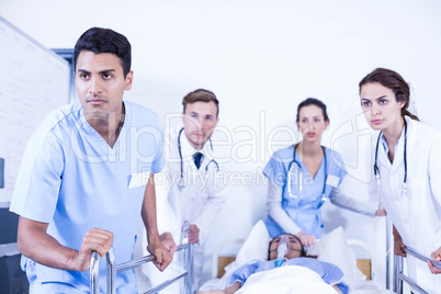 Concerned doctors standing near patient on bed