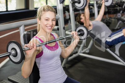Fit woman lifting barbell