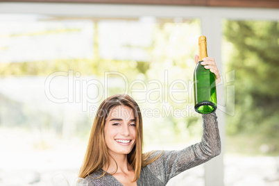 Portrait of beautiful woman holding champagne bottle