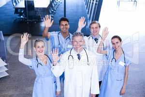 Group of medical team standing with their hand raised