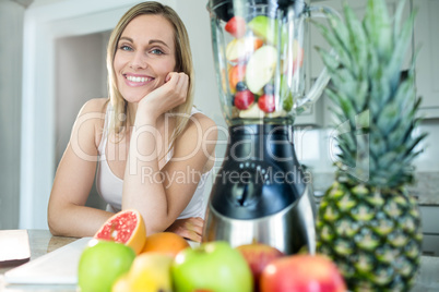Pretty blonde woman happy to prepare a smoothie