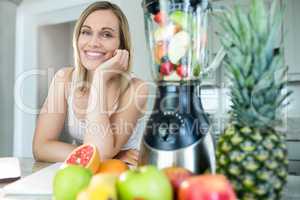 Pretty blonde woman happy to prepare a smoothie