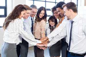 Businesspeople stacking hands in office