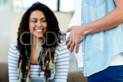 Woman looking at her pregnant partners belly