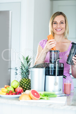 Blonde woman preparing a smoothie in the kitchen