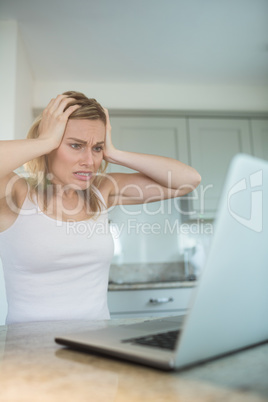 Pretty blonde woman looking at laptop