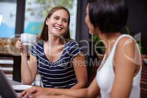 Smiling women having coffee together