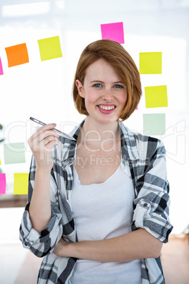 smiling hipster woman holding a pen in her hand