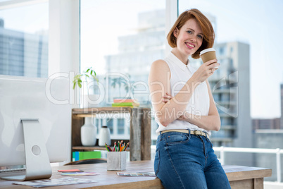 smiling hipster business woman drinking coffee in her office