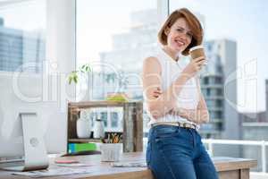 smiling hipster business woman drinking coffee in her office