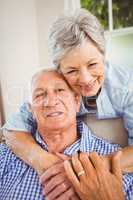 Senior woman embracing man at home